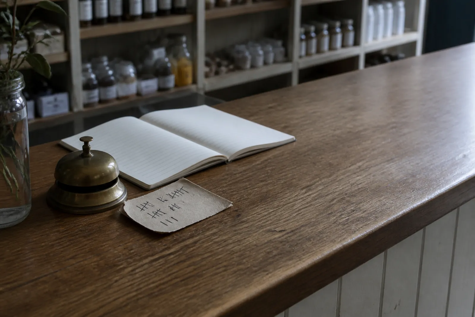 A paper tally of tick marks beside a counter bell and an open notebook.